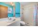 Bright bathroom with blue accent wall, white vanity, and tiled shower at 507 4Th Sw Ave, Largo, FL 33770