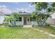Charming home with light yellow siding, covered porch, and tropical landscaping with palm trees at 507 4Th Sw Ave, Largo, FL 33770