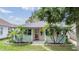 Charming home with light yellow siding, covered porch, and tropical landscaping with palm trees at 507 4Th Sw Ave, Largo, FL 33770
