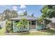 Charming exterior view of the home featuring a front porch, palm trees, and manicured landscaping at 507 4Th Sw Ave, Largo, FL 33770