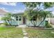 A charming home exterior featuring a lovely front porch, palm trees, and professionally maintained landscaping at 507 4Th Sw Ave, Largo, FL 33770