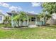 A charming home exterior featuring a lovely front porch, palm trees, and professionally maintained landscaping at 507 4Th Sw Ave, Largo, FL 33770