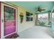 Inviting covered porch with turquoise accents, fan, decorative mask, and a peek at the outdoor garden at 507 4Th Sw Ave, Largo, FL 33770