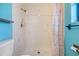 Shower features white tile, seashell shower curtain, and blue accent wall at 507 4Th Sw Ave, Largo, FL 33770