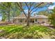 Expansive backyard featuring a covered patio, lush green lawn, and mature trees offering plenty of shade at 5102 White Pine Ne Cir, St Petersburg, FL 33703
