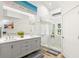 Bright bathroom with double vanity, glass enclosed shower, and beach-themed decor at 5102 White Pine Ne Cir, St Petersburg, FL 33703