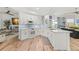 Modern kitchen with white cabinets, stainless steel appliances, backsplash and wood flooring at 5102 White Pine Ne Cir, St Petersburg, FL 33703