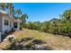 Expansive backyard featuring a lush lawn, mature trees, and a glimpse of neighboring houses, offering serene outdoor space at 5270 Miller Bayou Dr, Port Richey, FL 34668