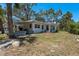 Charming white home with a well-maintained lawn, showcasing a cozy outdoor patio and lush surrounding greenery at 5270 Miller Bayou Dr, Port Richey, FL 34668