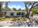 Charming single-story home with a well-manicured front yard, blue shutters and lush landscaping at 5270 Miller Bayou Dr, Port Richey, FL 34668