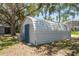 Durable metal shed with a barn-style roof, offering ample storage space on a grassy lawn surrounded by mature trees at 5270 Miller Bayou Dr, Port Richey, FL 34668