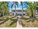 Backyard view of a two-story home with a brick path, seating area, and covered deck, perfect for relaxation at 5331 Bayou Grande Ne Blvd, St Petersburg, FL 33703