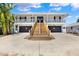Stunning two-story home featuring dual garages, wooden stairs leading to the entrance, and a charming balcony at 5331 Bayou Grande Ne Blvd, St Petersburg, FL 33703
