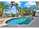 Sparkling pool surrounded by brick pavers, lush landscaping, and comfortable seating area, ideal for relaxation at 5331 Bayou Grande Ne Blvd, St Petersburg, FL 33703