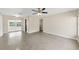 Spacious open-concept living area features polished concrete floors, a ceiling fan, and sliding glass door to the outdoors at 5961 41St N Ave, St Petersburg, FL 33709