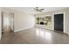 Open living room with sleek polished floors, a ceiling fan, a large multi-pane front window, and a dark front door at 5961 41St N Ave, St Petersburg, FL 33709