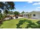 Grassy backyard with in-ground pool, lounge chairs, patio furniture, and privacy fence at 6006 114Th N Ter, Pinellas Park, FL 33782