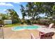 Landscaped backyard with a pool, patio, storage shed, and lush plantings at 6006 114Th N Ter, Pinellas Park, FL 33782