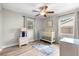 Bright Bedroom with wood floors, fan, crib, and windows letting in natural light at 6006 114Th N Ter, Pinellas Park, FL 33782