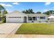 Charming single-story home featuring a well-manicured lawn, attached garage, and white exterior at 6006 114Th N Ter, Pinellas Park, FL 33782