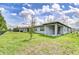 Large backyard with lush grass and a covered patio perfect for outdoor entertaining and relaxation at 6119 Bradford Woods Dr, Zephyrhills, FL 33542