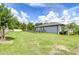 Spacious backyard with lush green grass enclosed by a sleek black fence, providing a secure area and ample space at 6119 Bradford Woods Dr, Zephyrhills, FL 33542