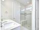 Bright bathroom featuring a double vanity and shower with glass door and seat at 6119 Bradford Woods Dr, Zephyrhills, FL 33542