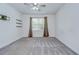Bright bedroom with ceiling fan, gray carpet, and a window with curtains at 6119 Bradford Woods Dr, Zephyrhills, FL 33542