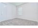 Bedroom with a gray carpet, a window letting in natural light and a closet with double doors at 6119 Bradford Woods Dr, Zephyrhills, FL 33542