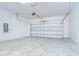 Spacious two-car garage featuring an automatic door opener and concrete flooring at 6119 Bradford Woods Dr, Zephyrhills, FL 33542