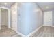 Hallway with wood floors and white doors providing access to various rooms at 6119 Bradford Woods Dr, Zephyrhills, FL 33542