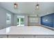 Open kitchen with a quartz countertop island and views into the living area with sliding glass doors at 6119 Bradford Woods Dr, Zephyrhills, FL 33542