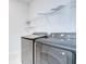 Well-lit laundry room featuring modern washer and dryer, and ample storage space with installed wire shelving at 6119 Bradford Woods Dr, Zephyrhills, FL 33542