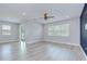 Bright living room features modern wood-look floors, recessed lighting, and a sliding glass door that leads to the yard at 6119 Bradford Woods Dr, Zephyrhills, FL 33542