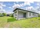 Covered patio with a sliding glass door that opens to a spacious green yard, perfect for relaxing outdoors at 6119 Bradford Woods Dr, Zephyrhills, FL 33542