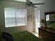 Bright bedroom with a ceiling fan, double door, and ample natural light from a large window at 6714 Dali Ave # 102, Land O Lakes, FL 34637