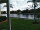 Relaxing patio view overlooking a serene lake, surrounded by palm trees and manicured landscaping at 6714 Dali Ave # 102, Land O Lakes, FL 34637