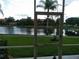 Screened-in patio view of the tranquil lake, lush trees, and well-maintained green spaces at 6714 Dali Ave # 102, Land O Lakes, FL 34637