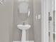 This is a half bathroom with a pedestal sink, oval mirror, and neutral paint at 6924 Towne Lake Rd, Riverview, FL 33578
