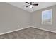 This is a carpeted bedroom with a window and a ceiling fan at 6924 Towne Lake Rd, Riverview, FL 33578