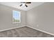 This is a carpeted bedroom with a window and a ceiling fan at 6924 Towne Lake Rd, Riverview, FL 33578