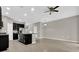 Open kitchen and living area with black cabinets and an island under a ceiling fan at 6924 Towne Lake Rd, Riverview, FL 33578