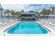 Community pool offering a relaxing spot, with lounge chairs, a clubhouse and a shady area nearby at 6960 Sunset S Dr # 2B, South Pasadena, FL 33707