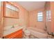 Bathroom featuring old sink, vanity, toilet, and a shower/tub combo at 7033 Wentworth Way, New Port Richey, FL 34655