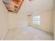 Bedroom features an open ceiling, deteriorated finishes and natural light at 7033 Wentworth Way, New Port Richey, FL 34655