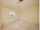 Empty bedroom with damaged ceiling and window overlooking the outside at 7033 Wentworth Way, New Port Richey, FL 34655