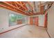A bedroom with exposed ceiling, damaged finishes and a boarded up door at 7033 Wentworth Way, New Port Richey, FL 34655