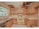 Outdated kitchen with damaged cabinets, countertops, and deteriorated ceiling at 7033 Wentworth Way, New Port Richey, FL 34655