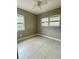 Bedroom featuring tile floors, ceiling fan, and natural light from two windows at 72 Lake Shore Dr, Palm Harbor, FL 34684