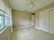 Bedroom features tile floors, a ceiling fan, and a double closet at 72 Lake Shore Dr, Palm Harbor, FL 34684